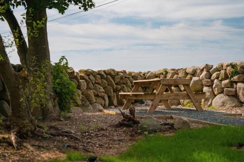 a wooden picnic table in front of a stone wall at The Brambles Retreat in the Mournes in Annalong