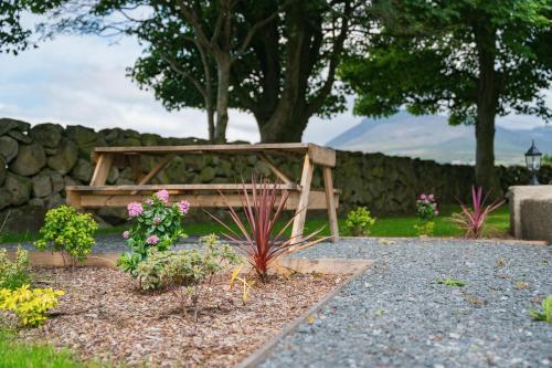 a wooden bench in a garden with flowers at The Brambles Retreat in the Mournes in Annalong