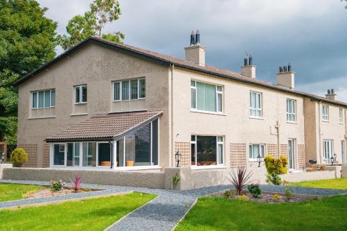 a large brick house with a lawn in front of it at The Brambles Retreat in the Mournes in Annalong