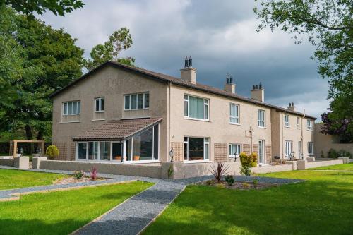 a large house with a green lawn in front of it at The Brambles Retreat in the Mournes in Annalong