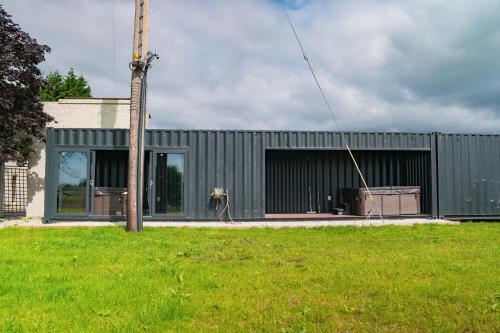 a gray building with a pole in the grass at The Brambles Retreat in the Mournes in Annalong