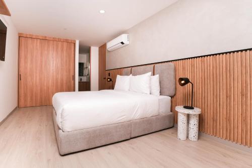 a bedroom with a white bed and a couch at Metropolitan Living by HOUSY in Medellín