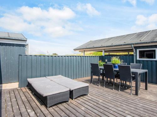 a patio with a table and chairs on a deck at 4 star holiday home in Blokhus-By Traum in Blokhus