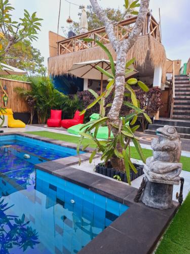 a house with a swimming pool with a tree next to it at Riccio Guest House & Cafe in Nusa Lembongan