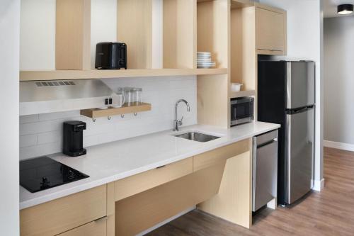 a kitchen with a sink and a refrigerator at TownePlace Suites by Marriott Calhoun in Calhoun
