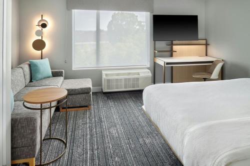 a hotel room with a bed and a couch and a table at TownePlace Suites by Marriott Calhoun in Calhoun
