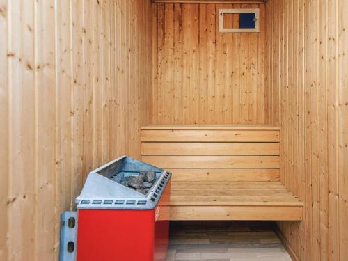 a wooden sauna with a red trash can in it at 6 person holiday home in Hjørring in Lønstrup
