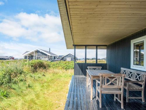 a wooden deck with a table and chairs on it at 6 person holiday home in Hjørring in Lønstrup