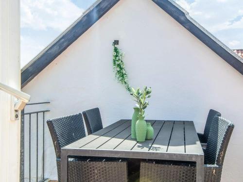a table with a green vase on top of a balcony at 4 star holiday home in Brønderslev in Brønderslev