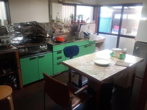 una cucina con armadi verdi e tavolo di Edo Tokyo Sharehouse Long Stay Only, One month plus a Tokyo