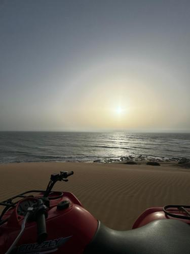 a motorcycle parked on the beach near the ocean at Domaine des Mimosas in Essaouira