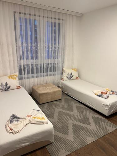 een kamer met twee bedden en een raam bij Fushkosov in Kosovo Polje