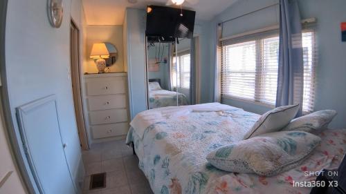 Un dormitorio con una cama, una cómoda y un espejo. en Coastal Adorable 1 bedroom 1 bath beach bungalow Located On Nettles Island, en Jensen Beach