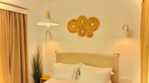 a bedroom with a bed and two clocks on the wall at Zorbas Family Villas in Skiathos Town