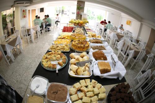 a long table filled with different types of food at Luz Hotel Pato Branco in Pato Branco