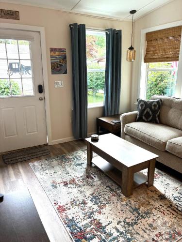 a living room with a couch and a coffee table at River Run Cottage Modern 2BR Waterfront Retreat in Linville Land Harbor in Newland