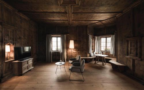 a living room with a couch and chairs and a television at Ansitz Heufler by Norbert Niederkofler in Rasun di Sopra