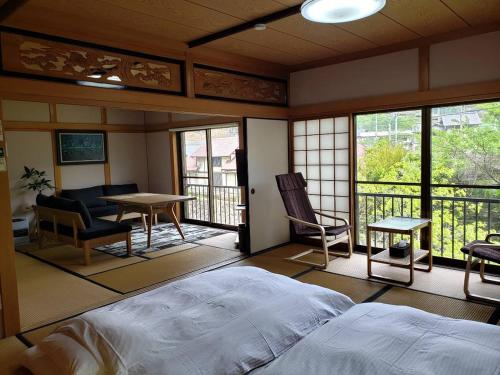 a bedroom with a bed and a table and chairs at ヴィラリバーサイド in Takamatsu