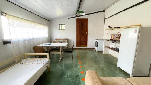 a living room with a table and a refrigerator at Catavento Pousada in Alto Paraíso de Goiás