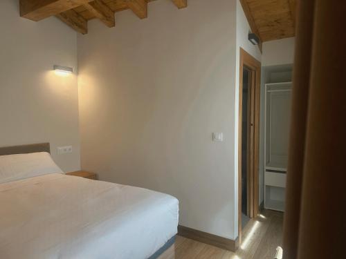 a bedroom with a white bed in a room at El Balcón de Potes in Potes