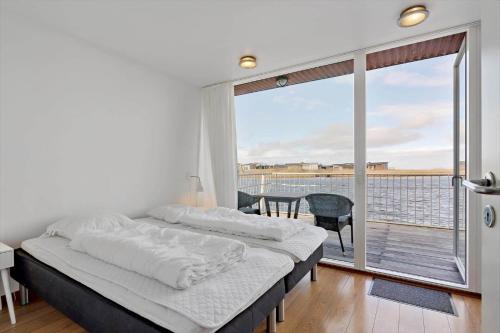 um quarto com uma cama grande e uma varanda em 790-Hvide-Sande-Ae-Gammel-Havn-49 em Hvide Sande