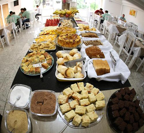 a long table filled with different types of food at Luz Hotel Pato Branco in Pato Branco