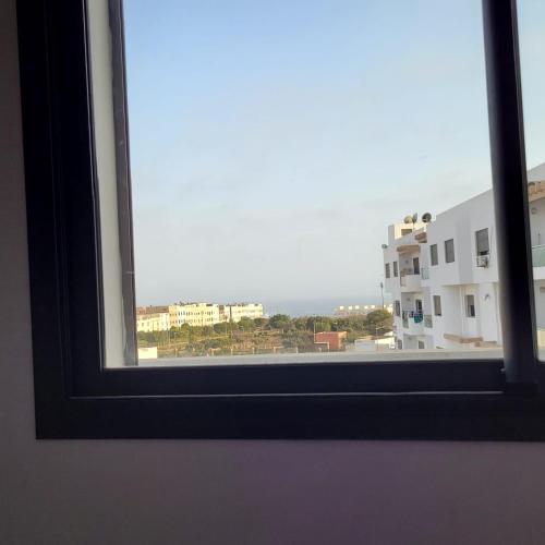 a window with a view of a building at Appartement moderne avec vue MER in Agadir
