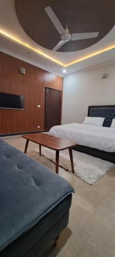 a bedroom with two beds and a coffee table at The Guest House Islamabad in Islamabad