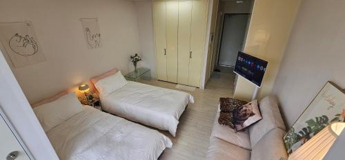 a living room with two beds and a couch at Baan Busan - 3mins to Haeundae Beach in Busan