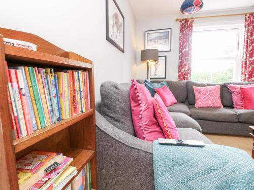 a living room with a couch and a book shelf with books at Milston in Ventnor