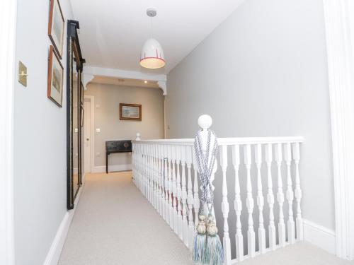 a white staircase in a home with a white railing at Milston in Ventnor