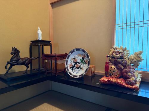 a table with a clock and a horse on it at 越前シーサイドゲストハウス オーシャンズ Echizen Seaside Guesthouse OCEAN'S in Fukui