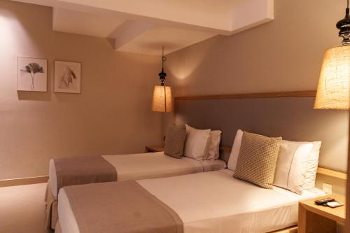 a hotel room with two beds and two lamps at Hotel Santa Cecilia B&B in Cartagena de Indias