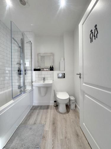 a white bathroom with a toilet and a sink at Eden Gateway full equipment brand new bright and modern En-suite Double bedroom - room 3 near city centre in Birmingham