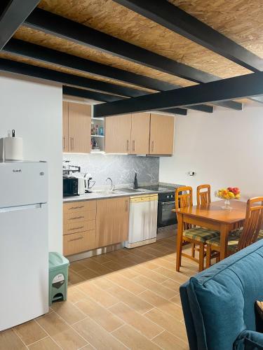 a kitchen and dining room with a table and a blue couch at Casas Chão da Roseira in Celorico da Beira