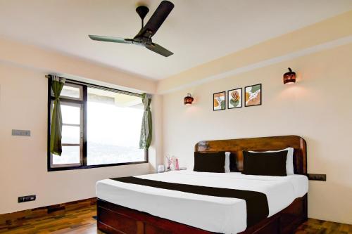 a bedroom with a bed with a ceiling fan at Hotel O Ranka Gangtok in Tādong