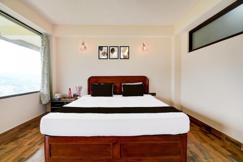 a bedroom with a large bed and a large window at Hotel O Ranka Gangtok in Tādong
