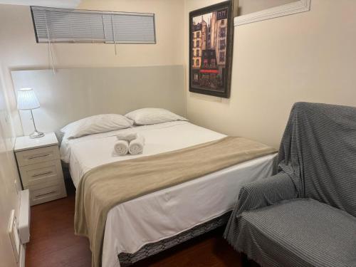 a small bedroom with a bed and a chair at Dunbar Guest Home close downtown Vancouver, UBC and store in Vancouver