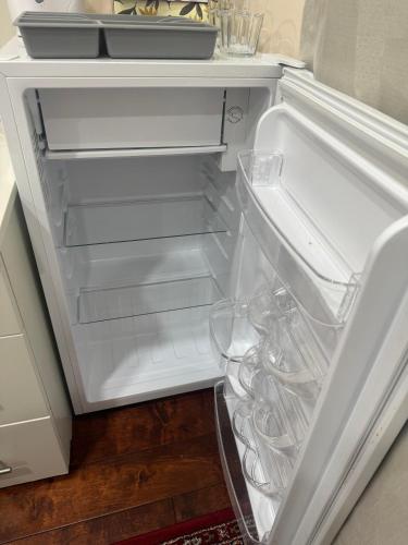 an empty refrigerator with its door open in a kitchen at Dunbar Guest Home close downtown Vancouver, UBC and store in Vancouver