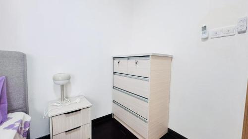 een witte slaapkamer met een dressoir en een bed bij 富力公主湾R&F Princess Cove by RongYu in Johor Bahru
