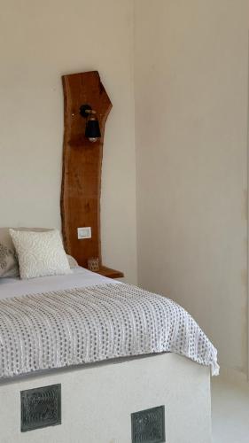 a bedroom with a white bed with a wooden headboard at Bassya Villa in Zarzis