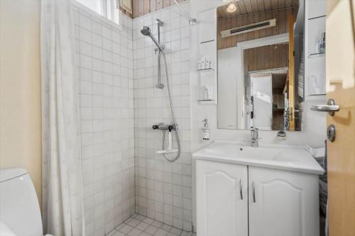ein weißes Badezimmer mit Dusche und Waschbecken in der Unterkunft 755 Hvide Sande - Søndergade 106 in Hvide Sande