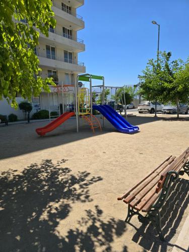 a park with a playground with a slide and a bench at Departamento Premium Full equipado in Rancagua