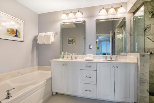 y baño blanco con bañera, lavamanos y bañera. en Luxe, Updated, Oceanfront Condo with Ground-Floor Patio, WiFi & Shared Pool, en Amelia Island