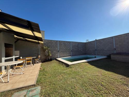 un patio trasero con piscina, mesa y sillas en Lomas, en Santiago del Estero