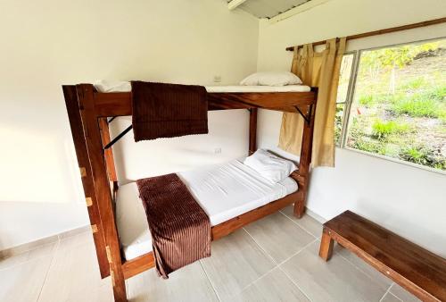 two bunk beds in a room with a window at La Granja De Bam Bam in Sasaima