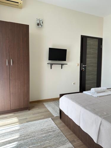 a bedroom with a bed and a flat screen tv at Aksa Apartments in Ulcinj