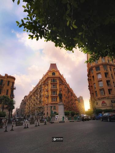 a large building on a street with two tall buildings at Italia Hotel cairo in Cairo