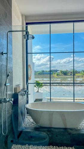 a large bathroom with a tub and a large window at The Alvarendra Ubud Villa By Bali Cabin in Ubud