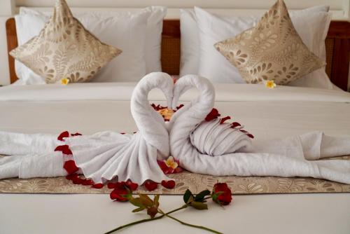 two swans made out of towels on a bed at The Alvarendra Ubud Villa By Bali Cabin in Ubud